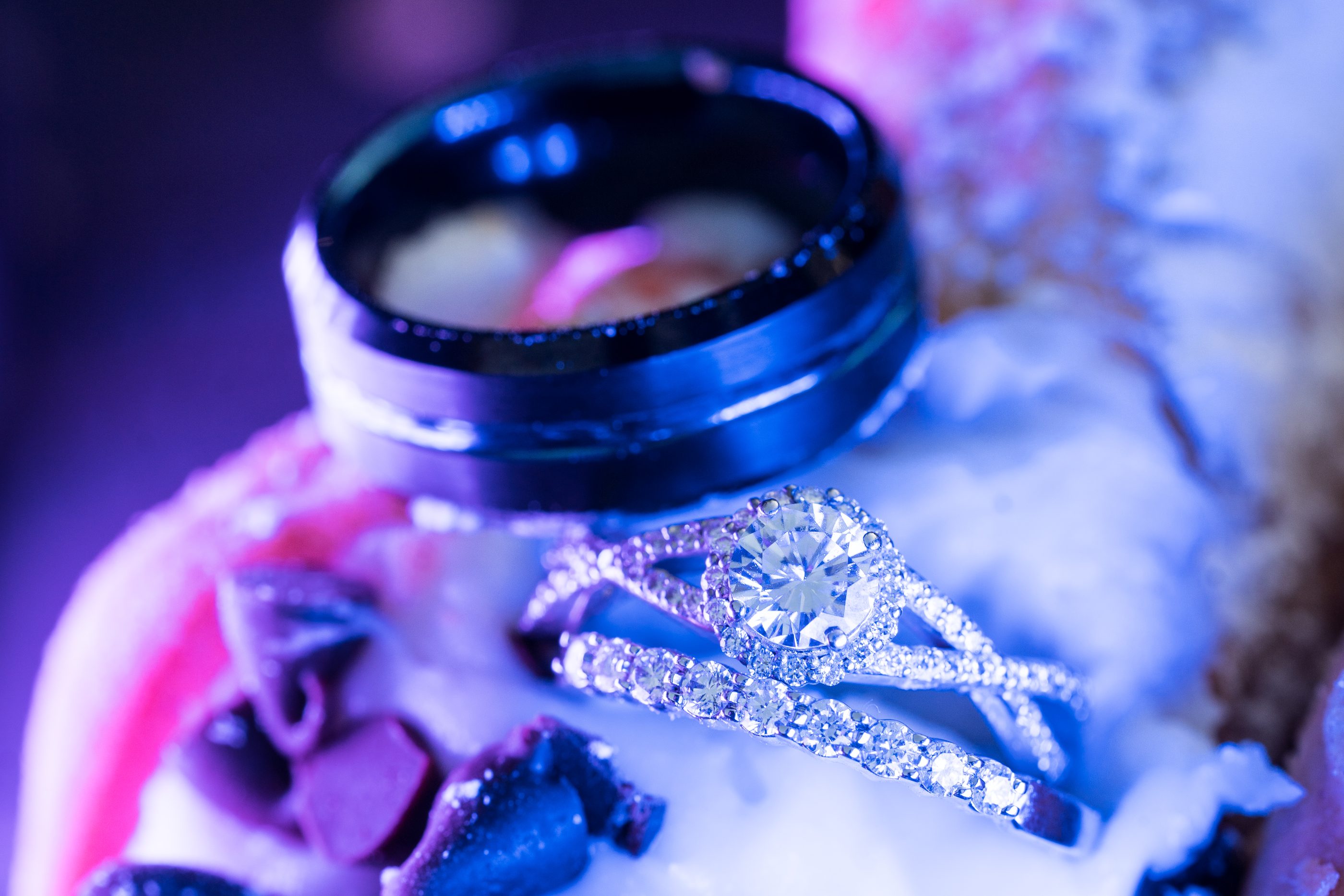 Abney and Chris's wedding band and engagement ring resting on an ice cream taco under purple light