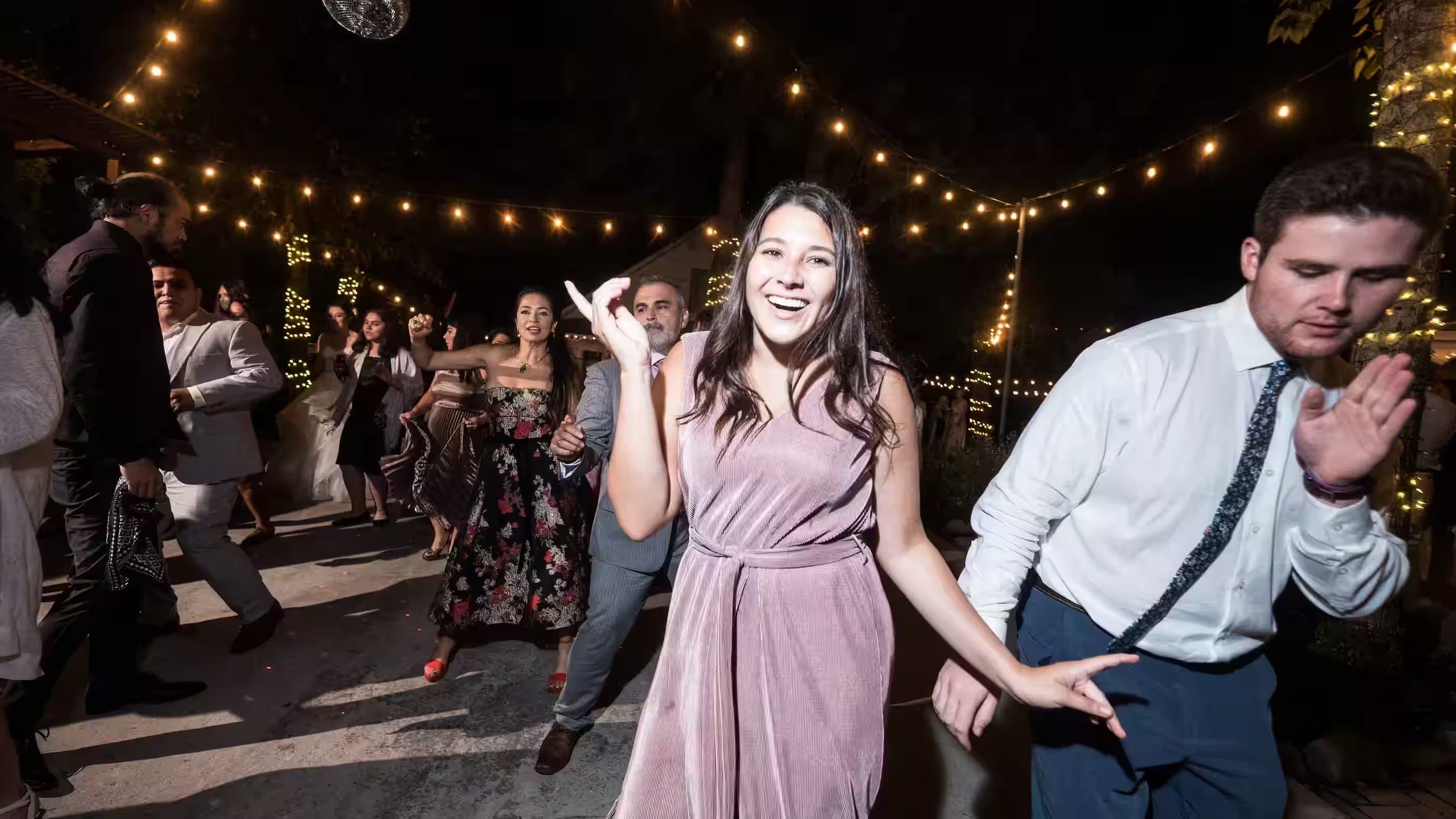 Wedding guests dancing at night reception