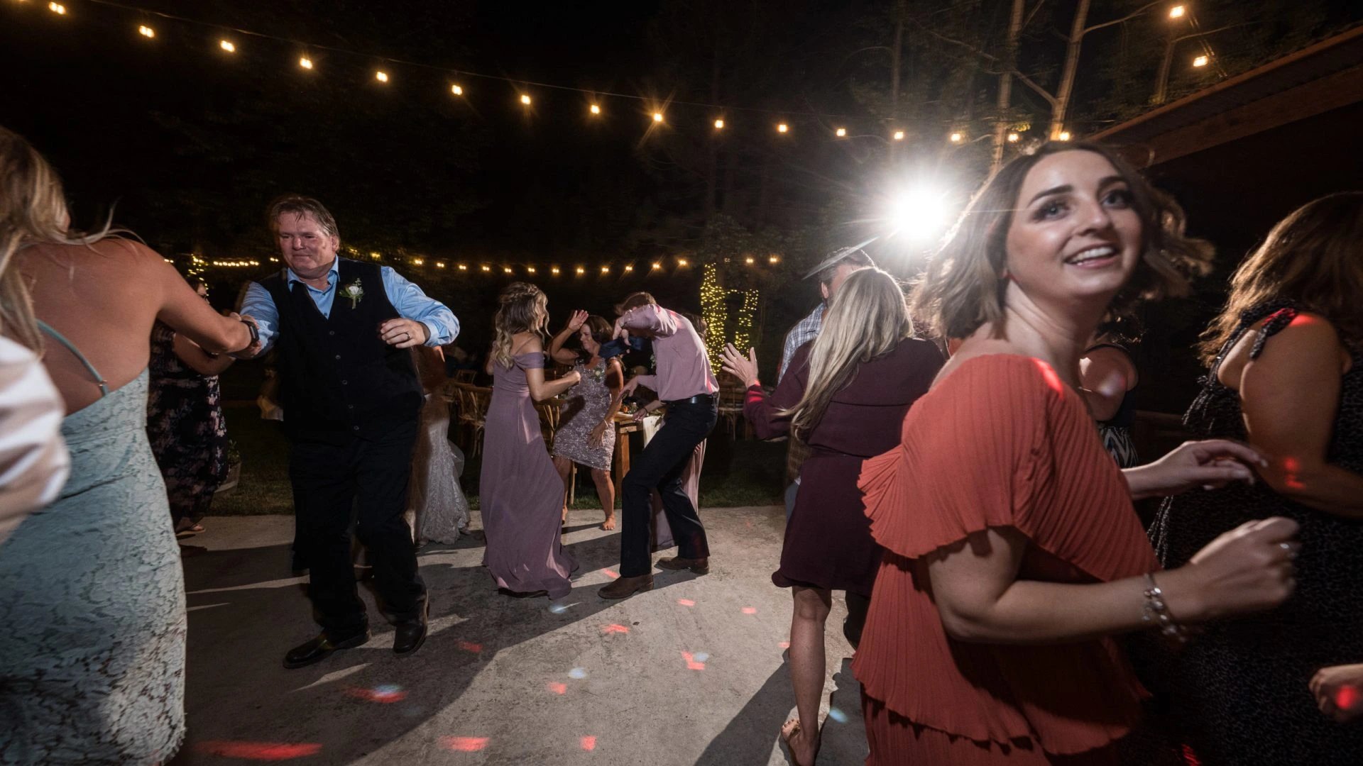 Wedding guests dancing under string lights at Correen and Kellen's reception in Graeagle