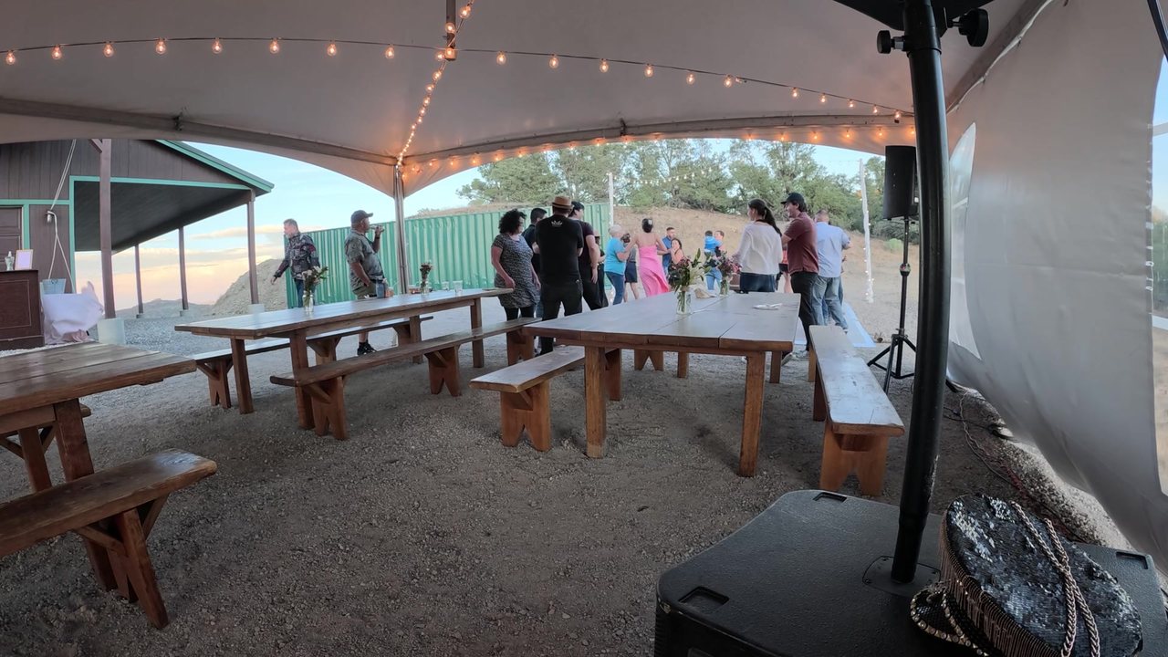 Guests dancing at the far end of the tent at golden hour