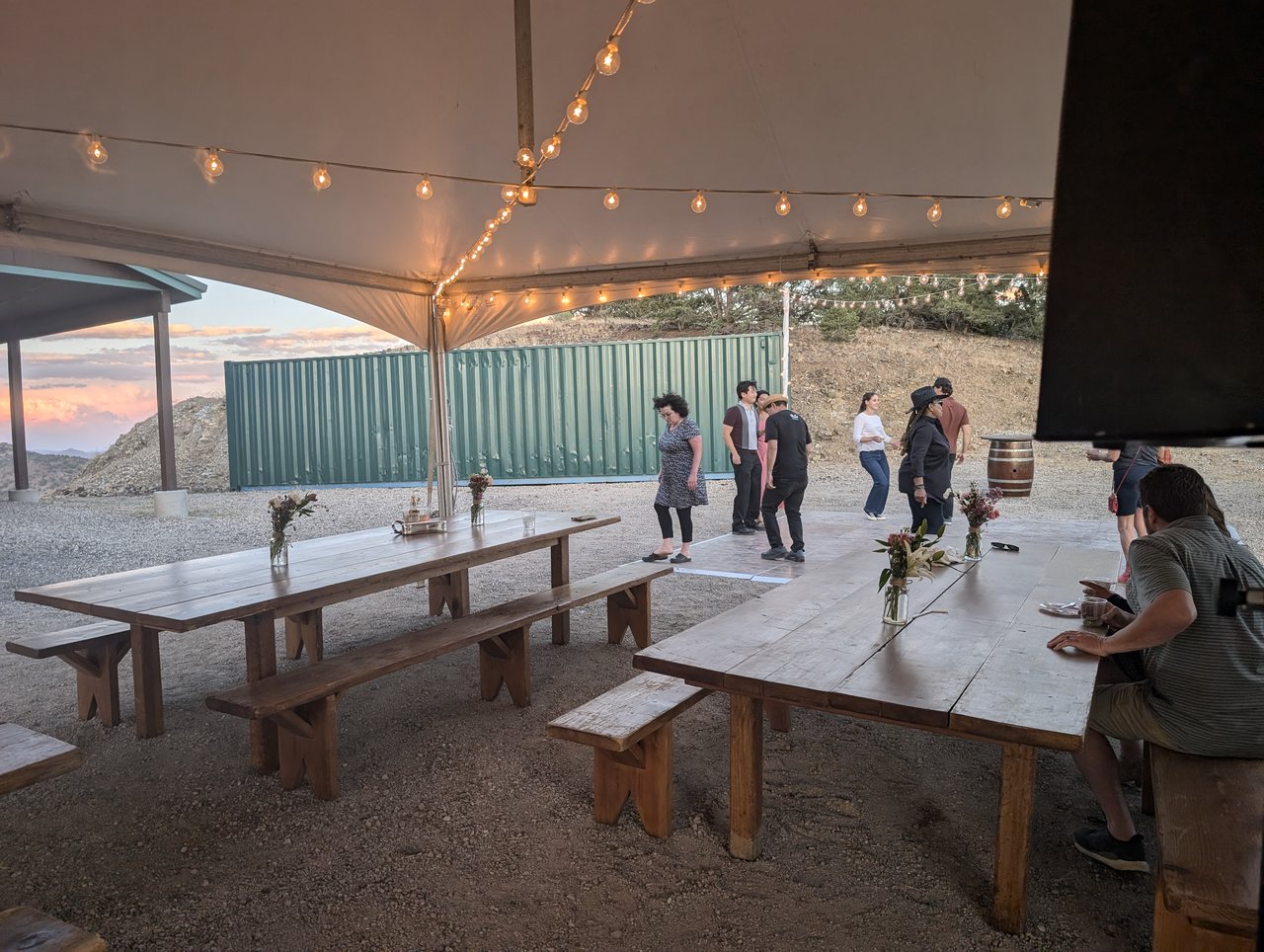 Guests dancing under the string lights of the tent at dusk
