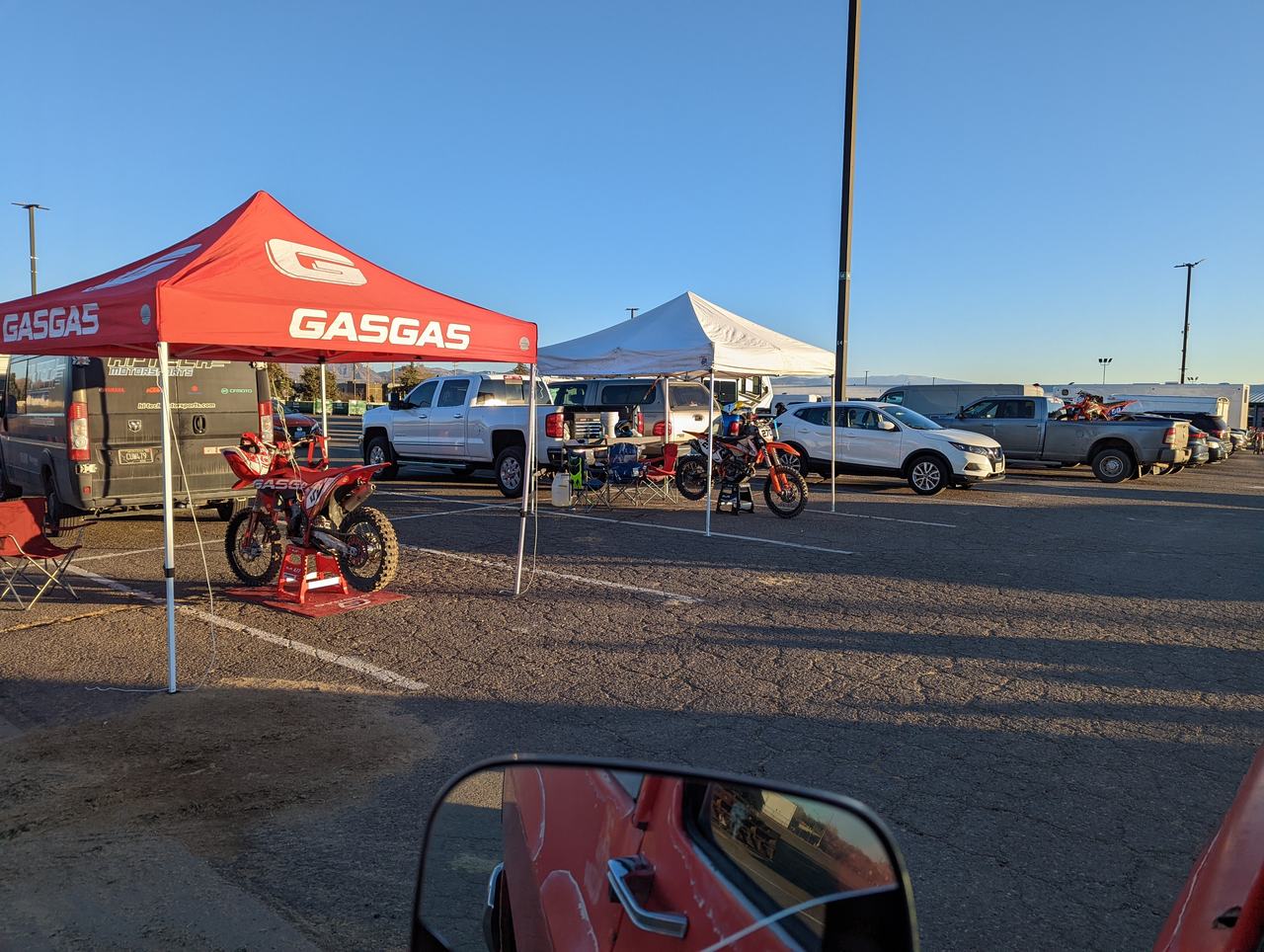 A GASGAS race bike under the team tent in the pits outside the arena