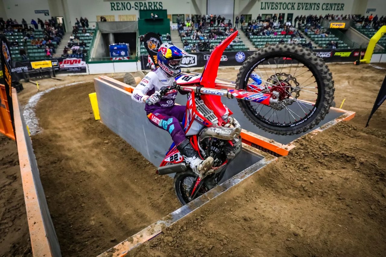 Jonny Walker wheeling his Beta up the log wall under the Reno Sparks Livestock Events Center sign, Betamotor press photo