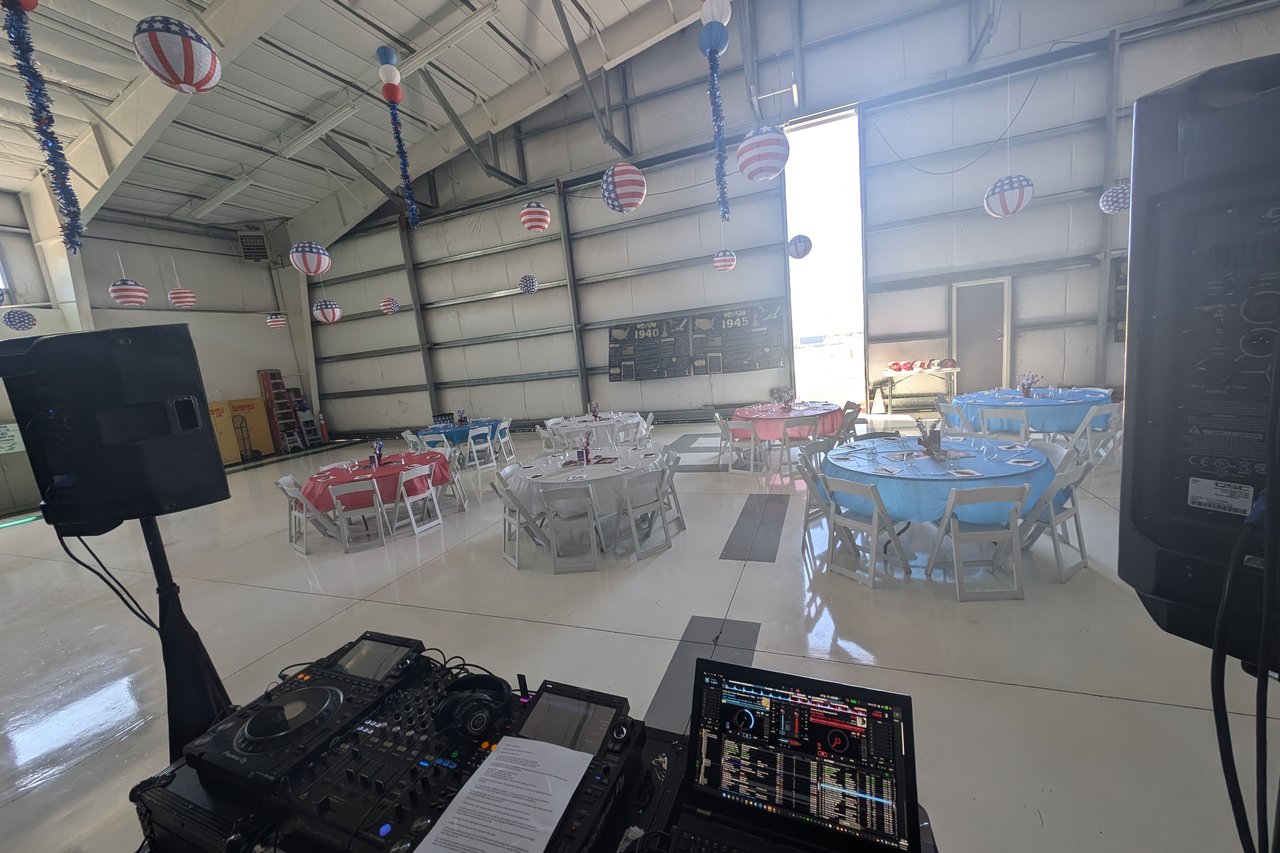 The decorated hangar and its red, white and blue tables seen from the DJ booth