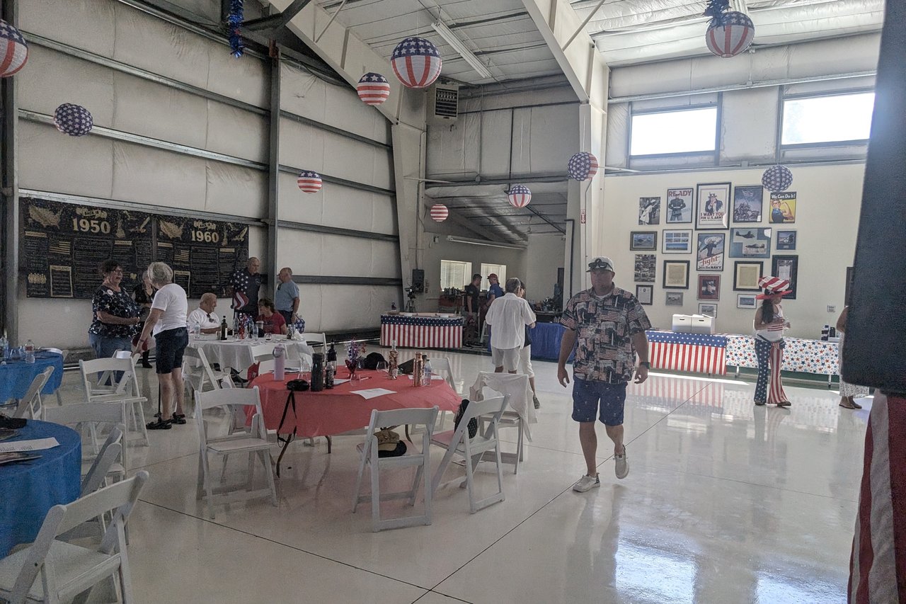 Guests mingling by the era boards and the memorabilia wall after the film