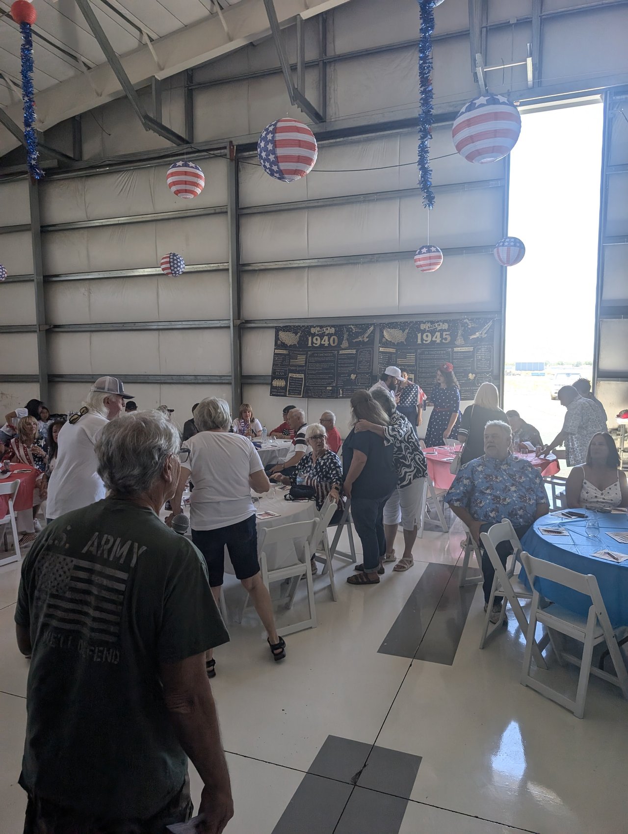 Guests settling in at the round tables under the flag lanterns before the welcome