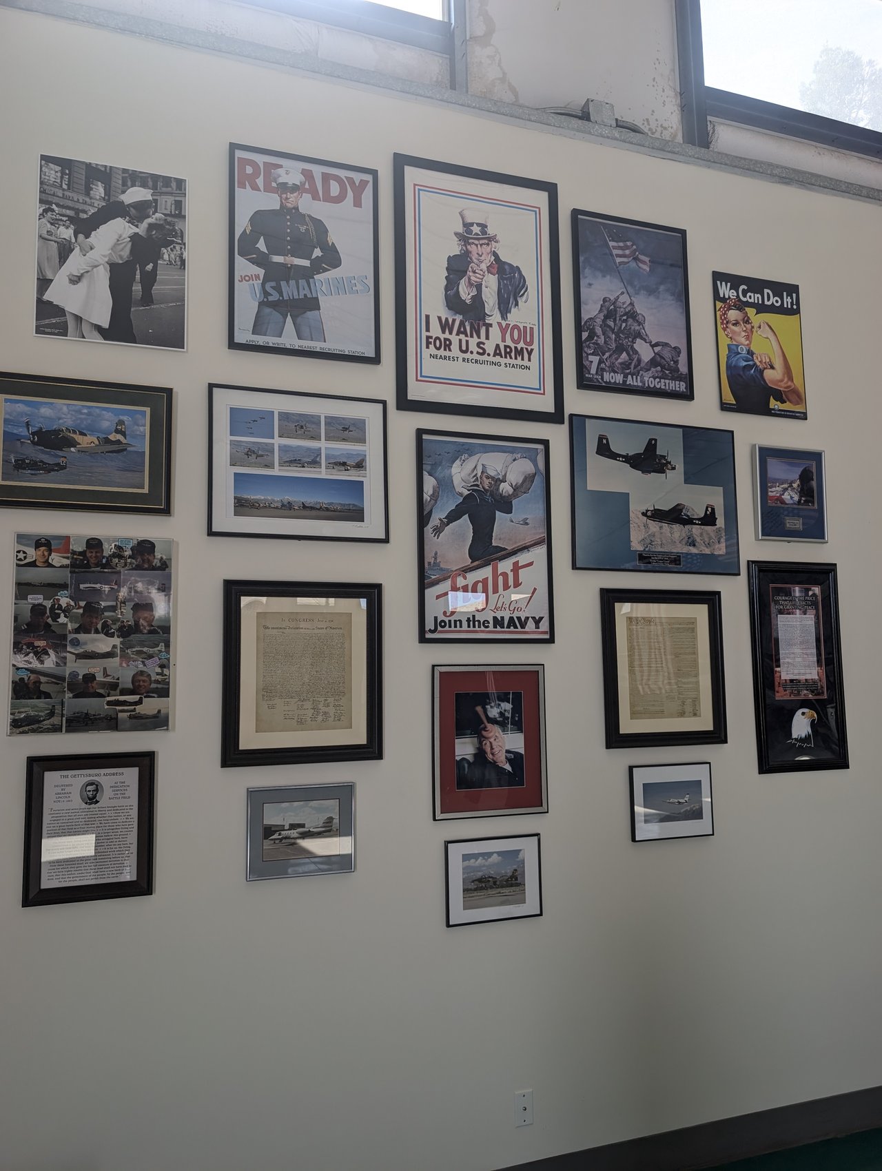 A wall of framed wartime posters and photos in the hangar
