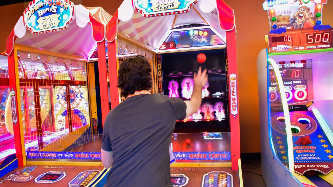 An AMUG guest tossing a ball at a carnival arcade game