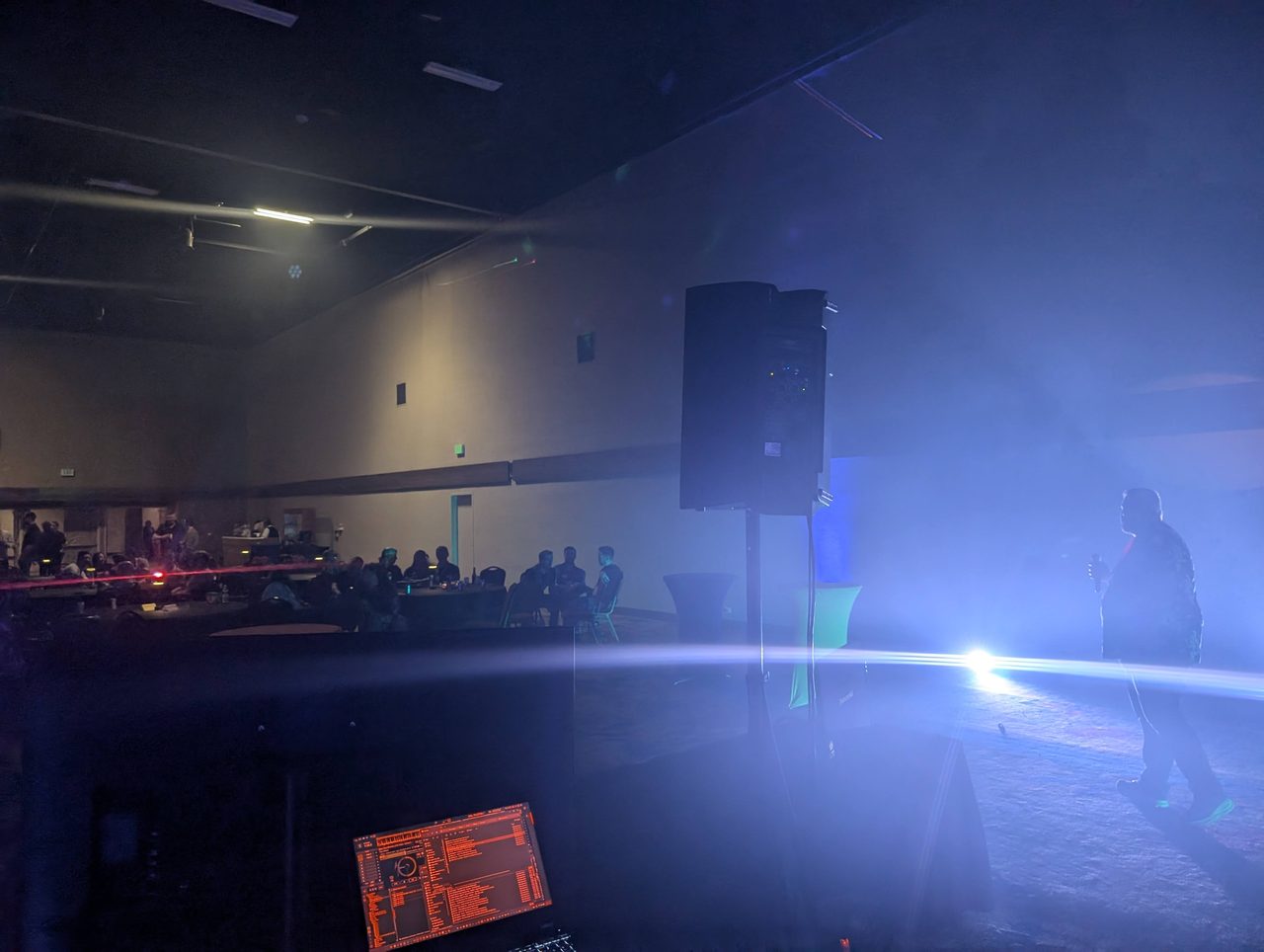 AMUG guests at their tables and a karaoke singer in the light on the second night