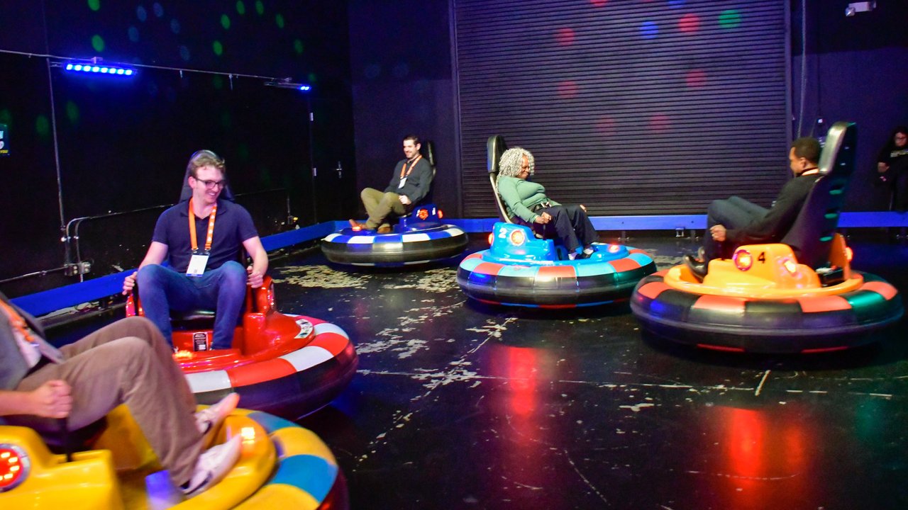 Four AMUG guests driving bumper cars across the arena floor
