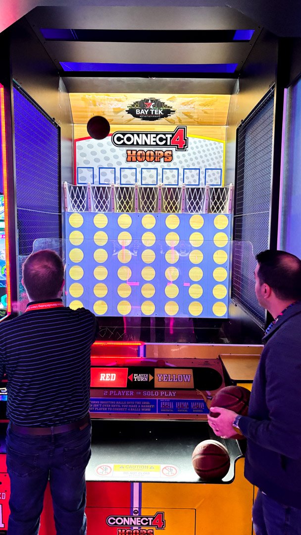 Two AMUG guests playing the Connect 4 Hoops arcade game