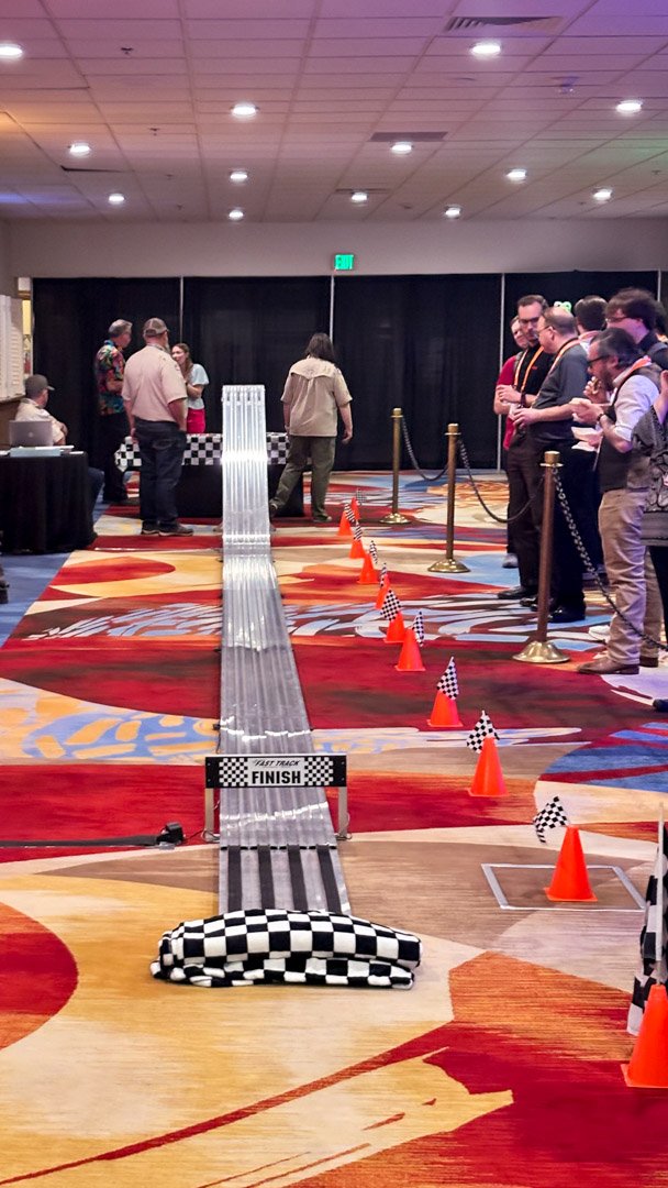 The derby track running down the middle of the game room to the finish line, with guests along the ropes