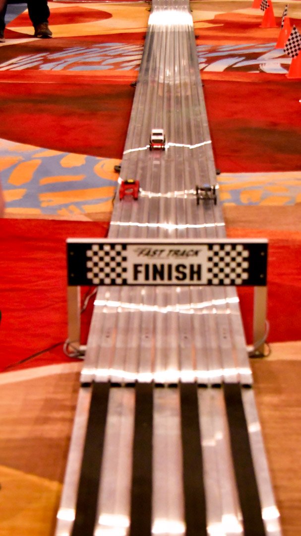 Derby cars crossing the checkered finish line on the race track