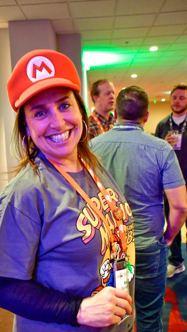 A smiling AMUG guest in a red Mario cap and a Super Mario shirt