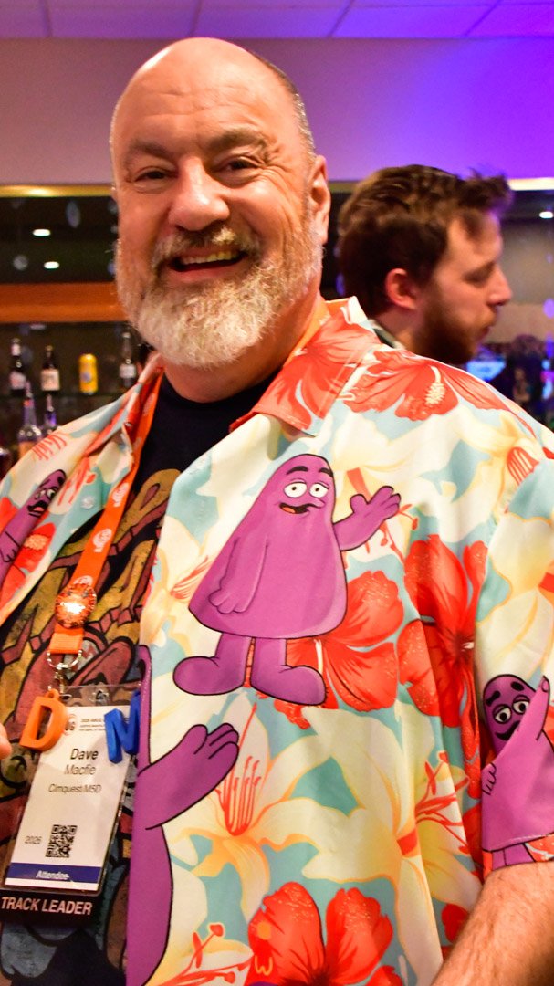 A smiling AMUG guest in a bright shirt covered in a purple cartoon character