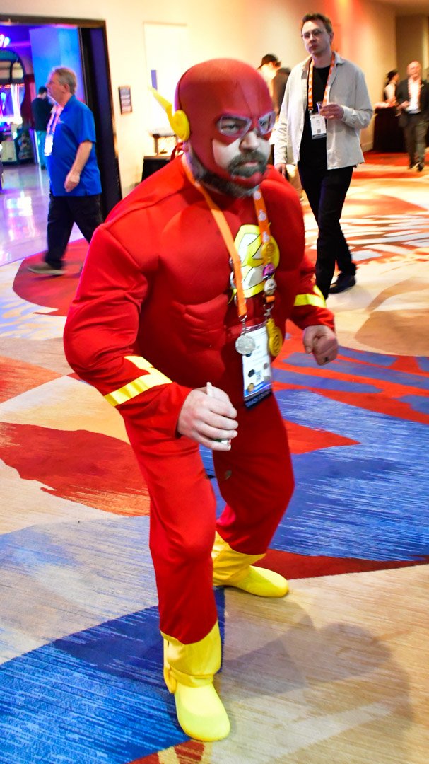 An AMUG guest in a red superhero suit striking a pose on the casino carpet