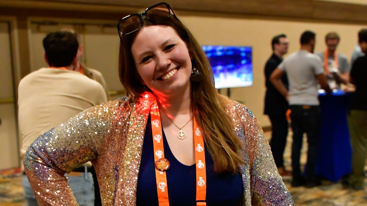 A smiling AMUG guest in a sparkly sequin jacket