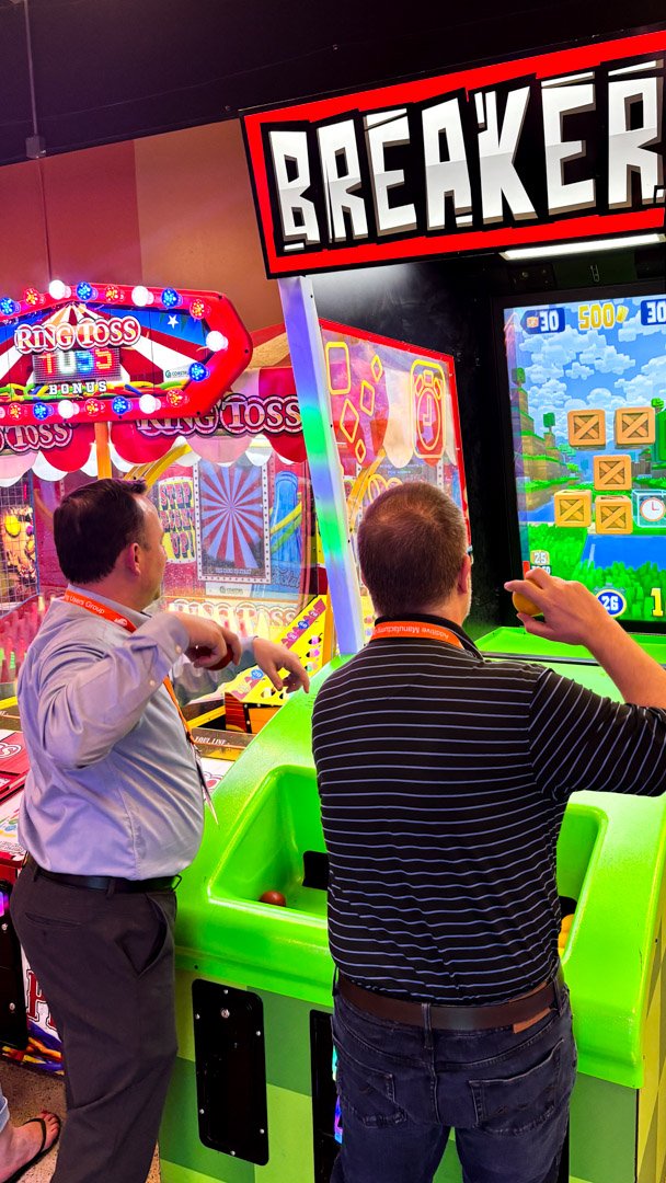 Two AMUG guests playing the Breaker arcade game
