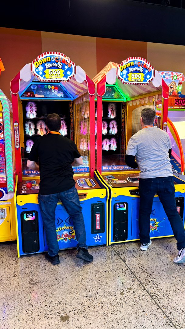 Two AMUG guests playing side by side clown arcade games