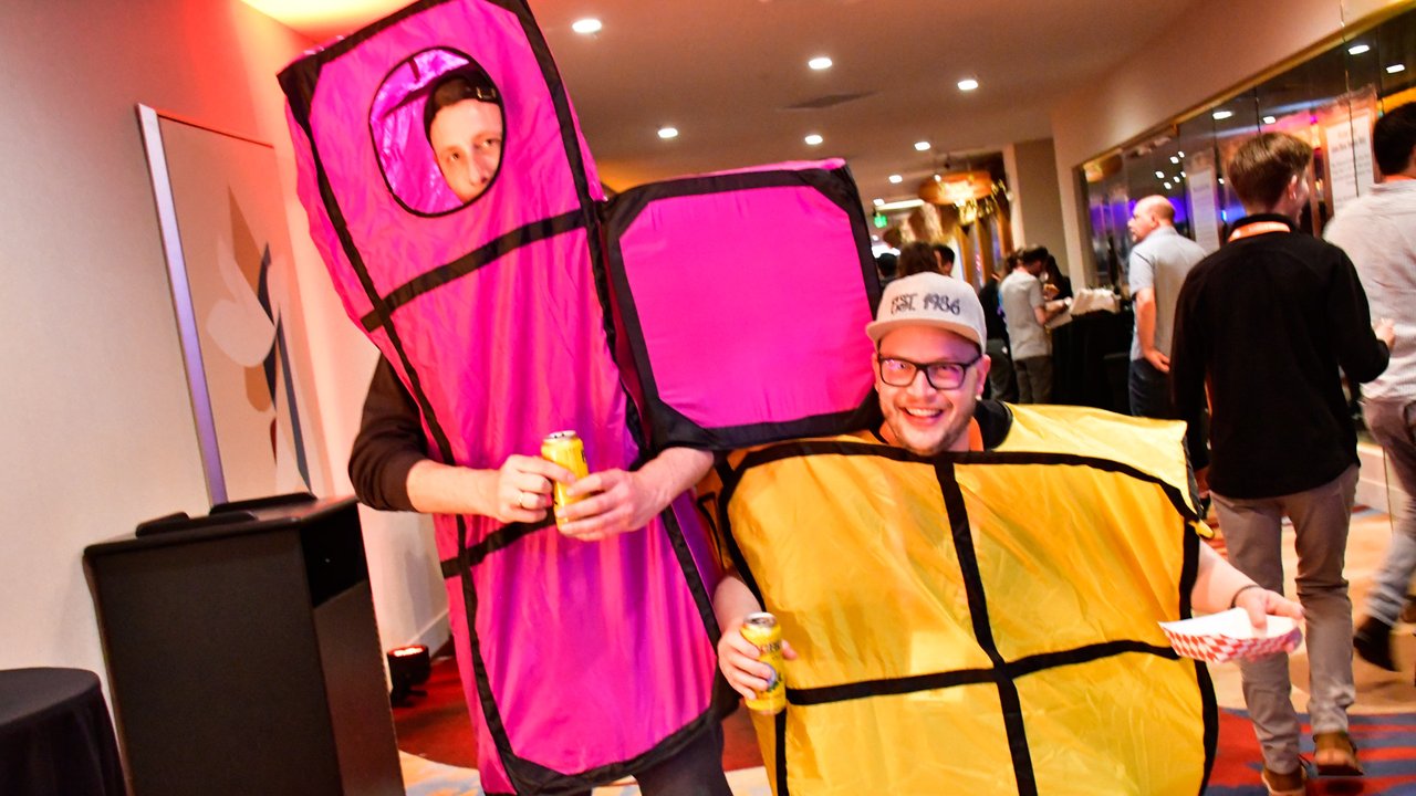Two AMUG guests dressed as pink and yellow falling block pieces
