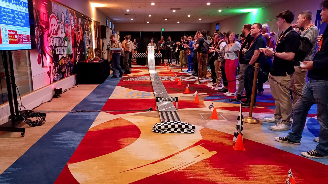 AMUG guests lined up along the derby race track in the game room