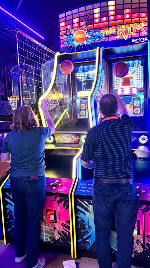 Two AMUG guests shooting hoops at the Rock The Rim arcade game