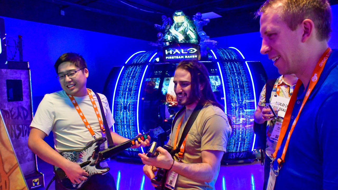 AMUG guests playing guitar controllers at the arcade