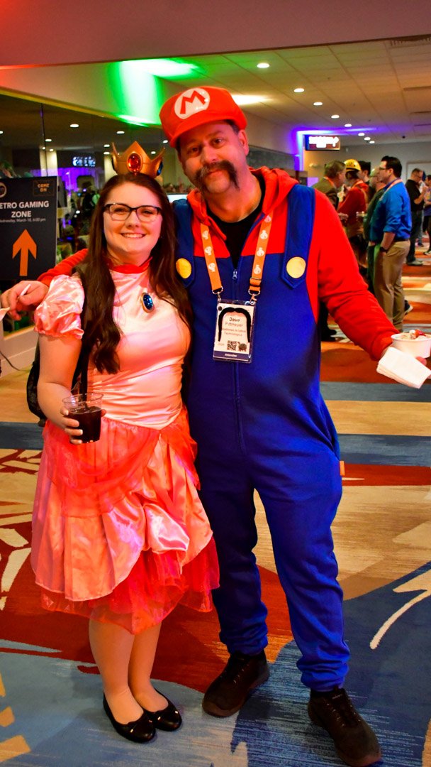Princess Peach and Mario costumes posing together on game night