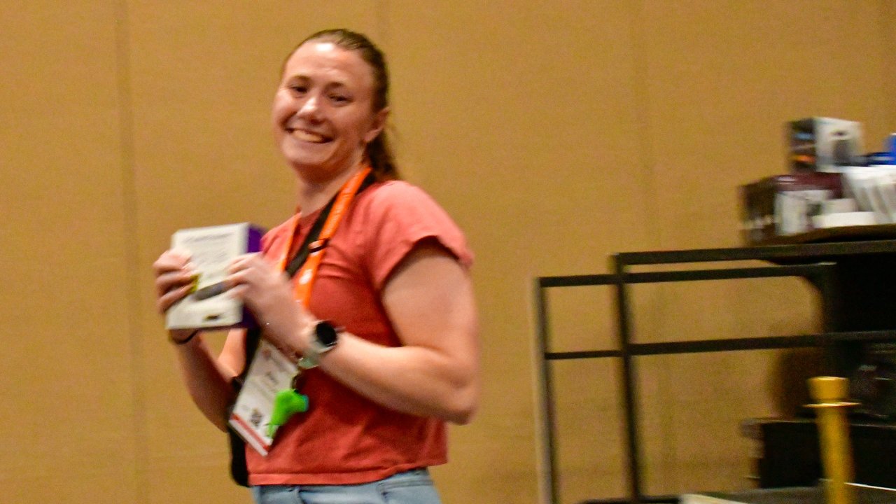A smiling AMUG guest walking up to collect her raffle prize