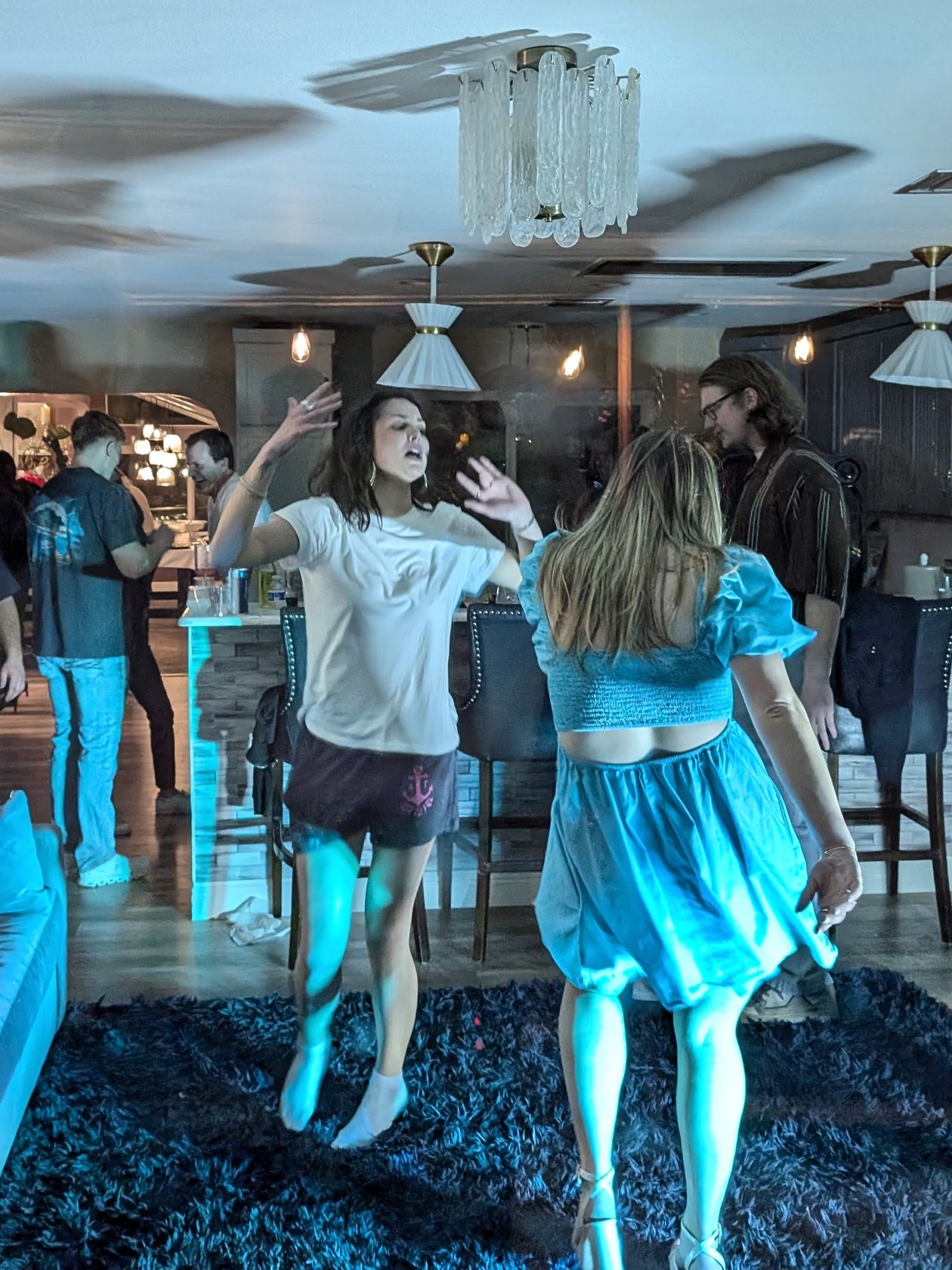 Guests dancing and singing in the living room at Niki’s 55th birthday party