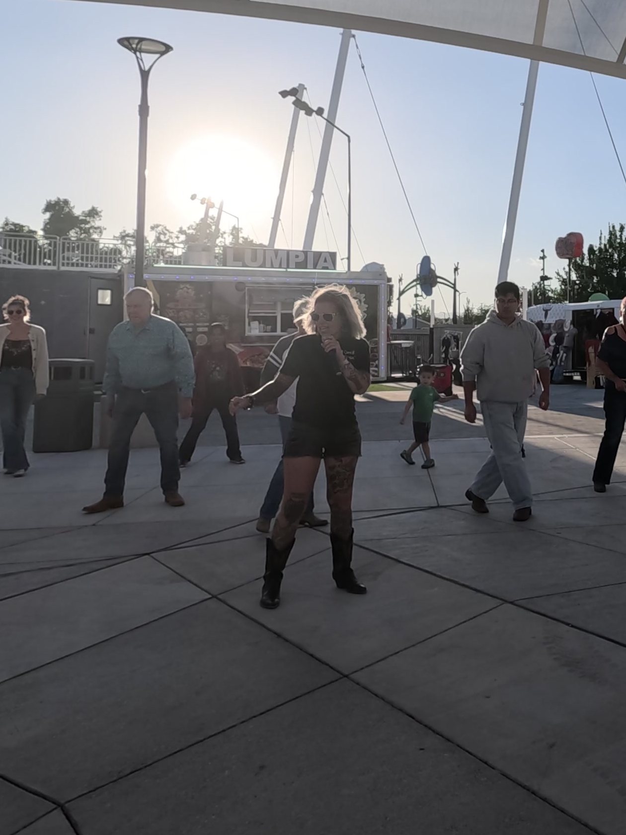 A line dance instructor leads the dancers in the evening sun at the Wanderlust Foodtrucks Festival in Reno