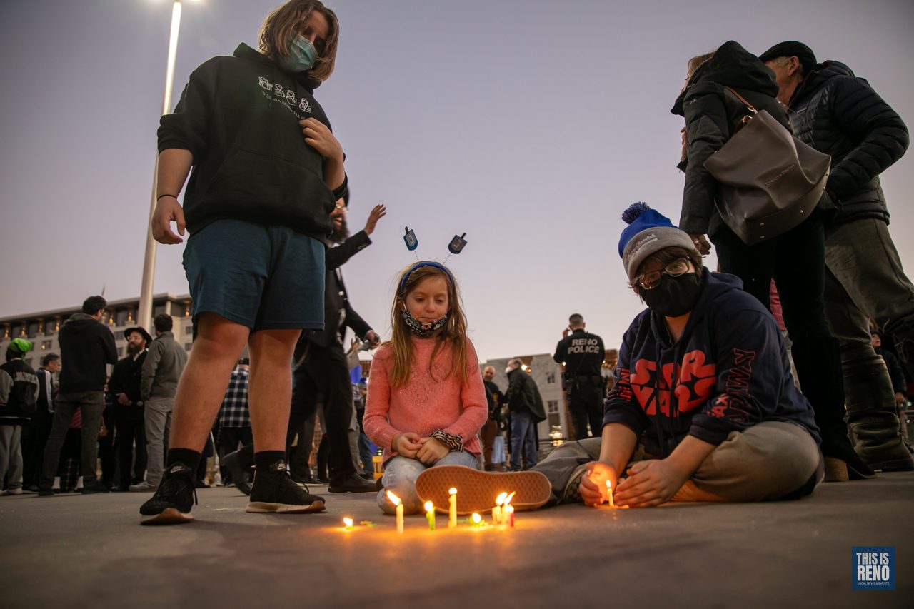 Candles glowing on the plaza as kids gather around them