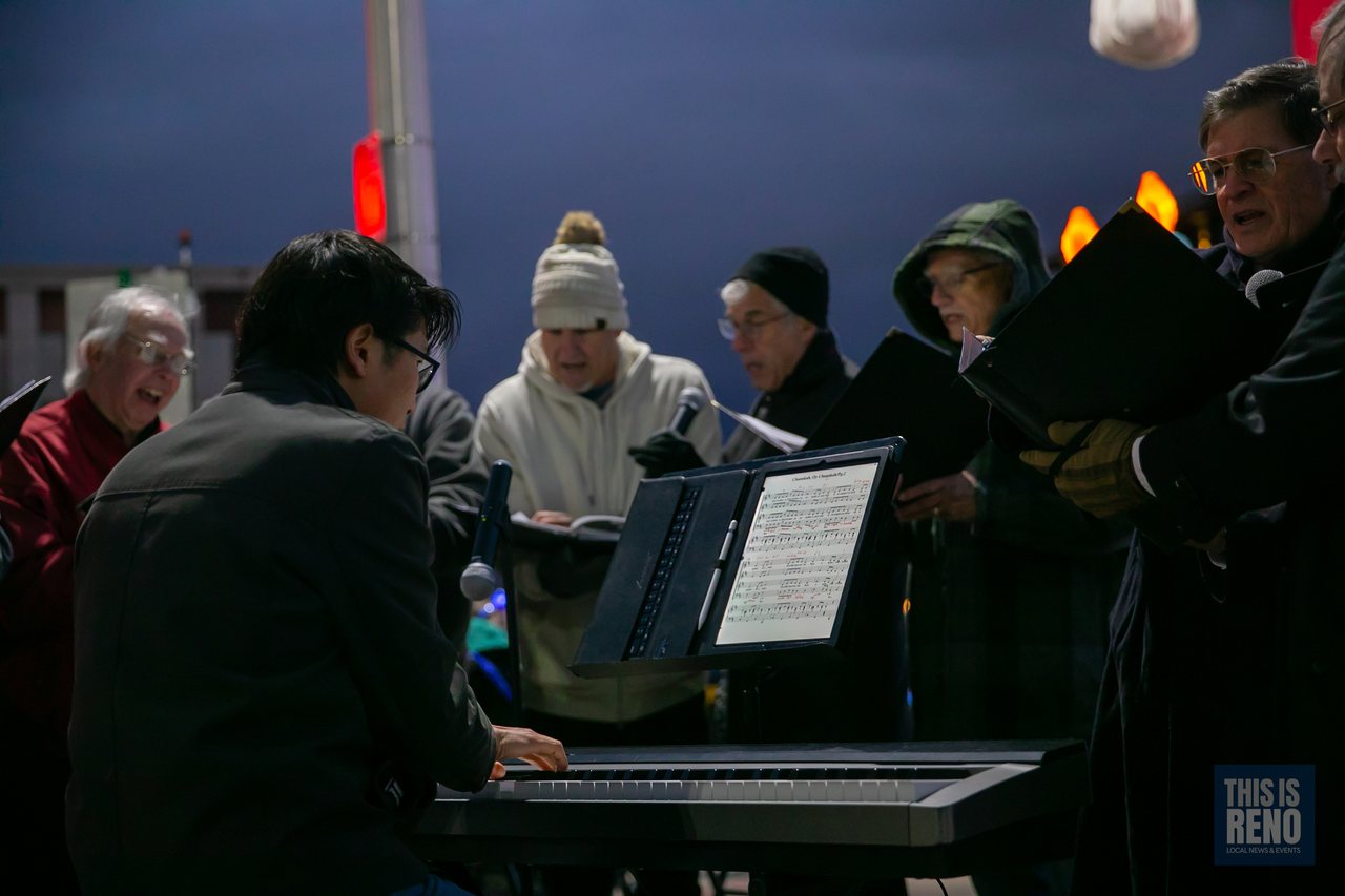 A choir singing with a keyboard player at the Menorah Lighting in City Plaza