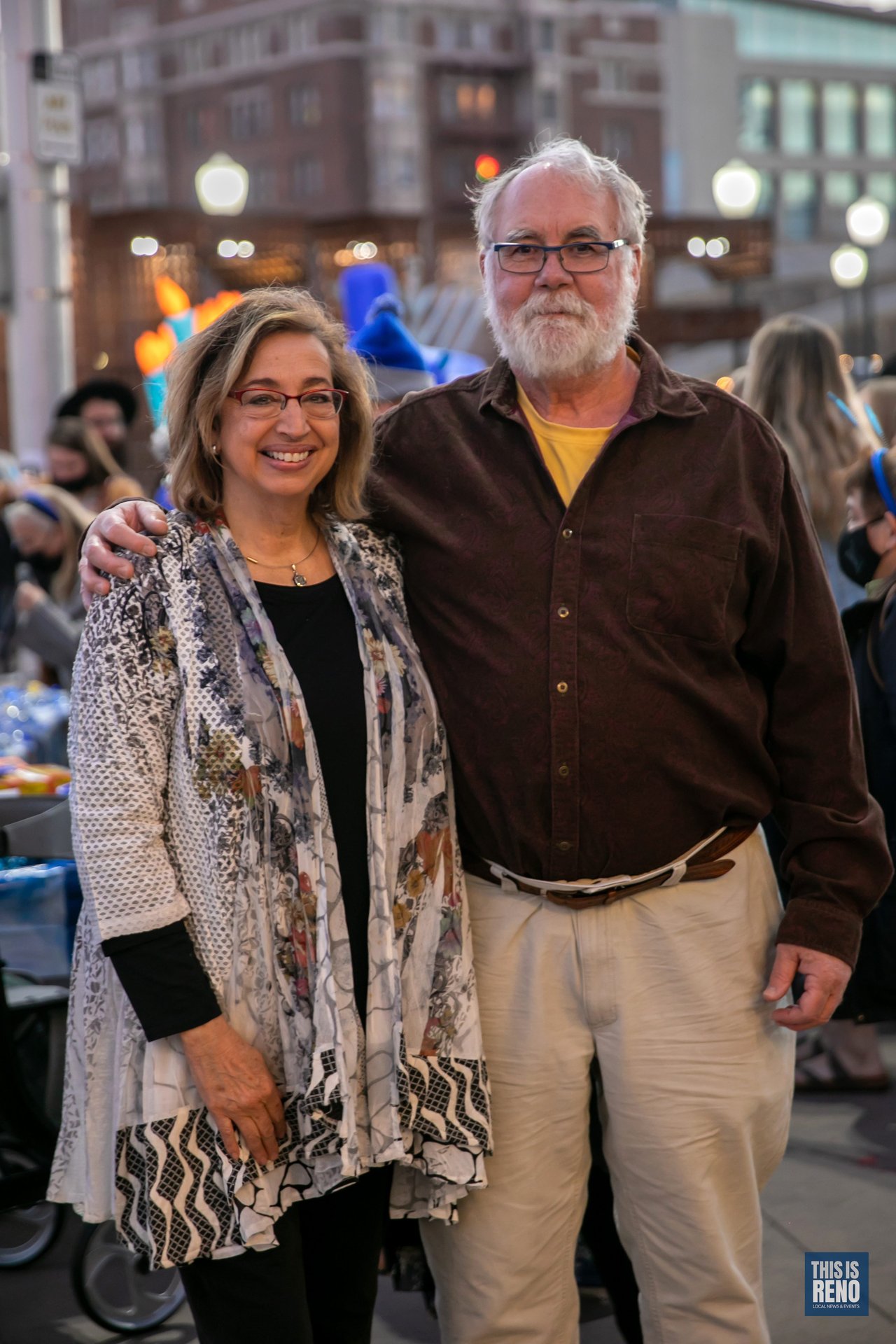 A couple poses together under the City Plaza lights