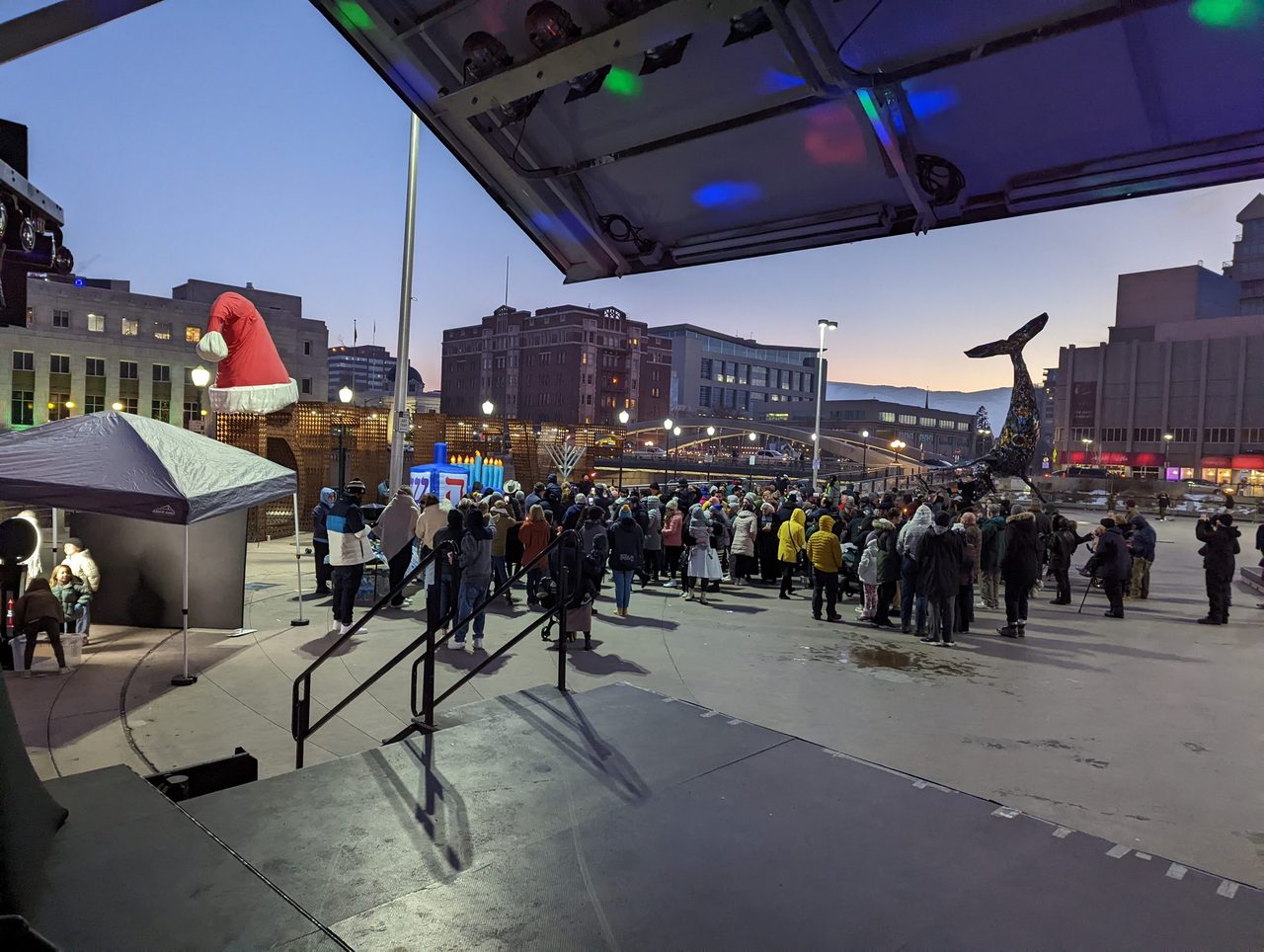 The crowd gathering in front of the stage at dusk in City Plaza, seen from the DJ booth