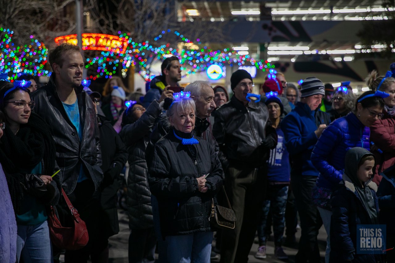 Families watch the ceremony under the plaza lights