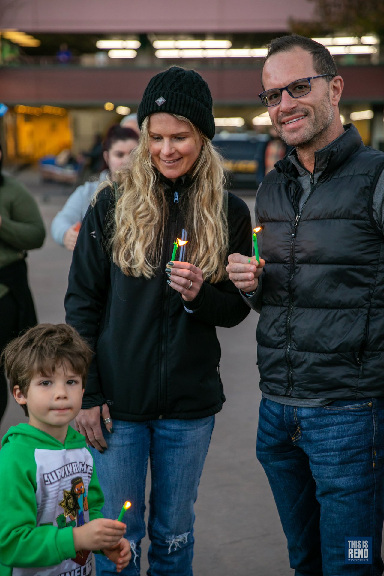A family holds candles together in City Plaza