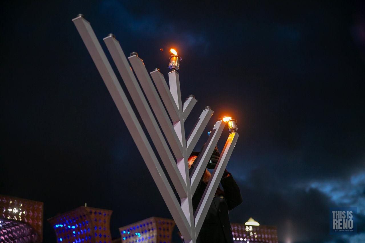 The first flame burns on the giant menorah