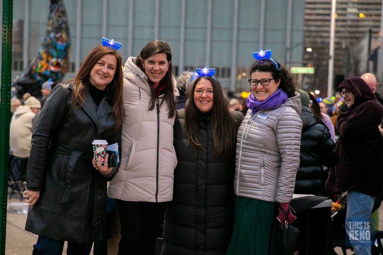 Friends in glowing menorah headbands at the ceremony