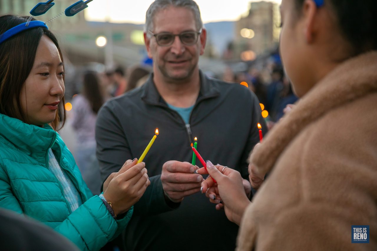 Guests lighting each other’s candles in the crowd