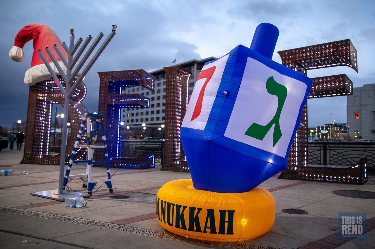The Chanukah dreidel and the menorah in front of the Believe sign