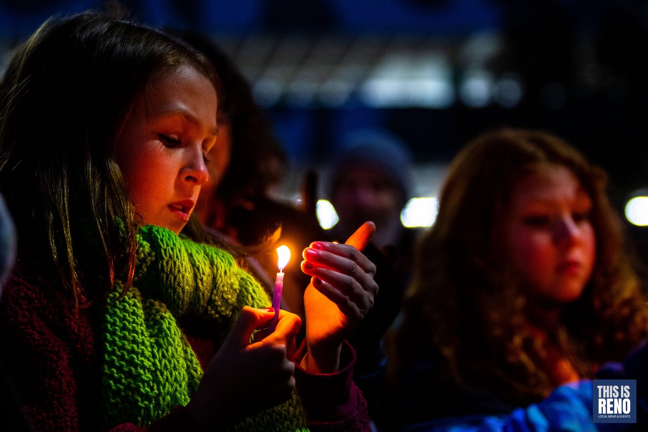 Kids holding lit candles in the crowd