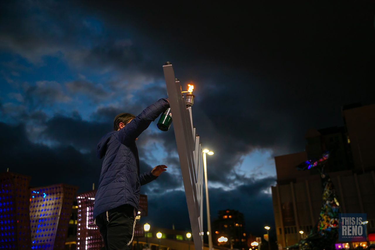 Lighting the menorah against the night sky