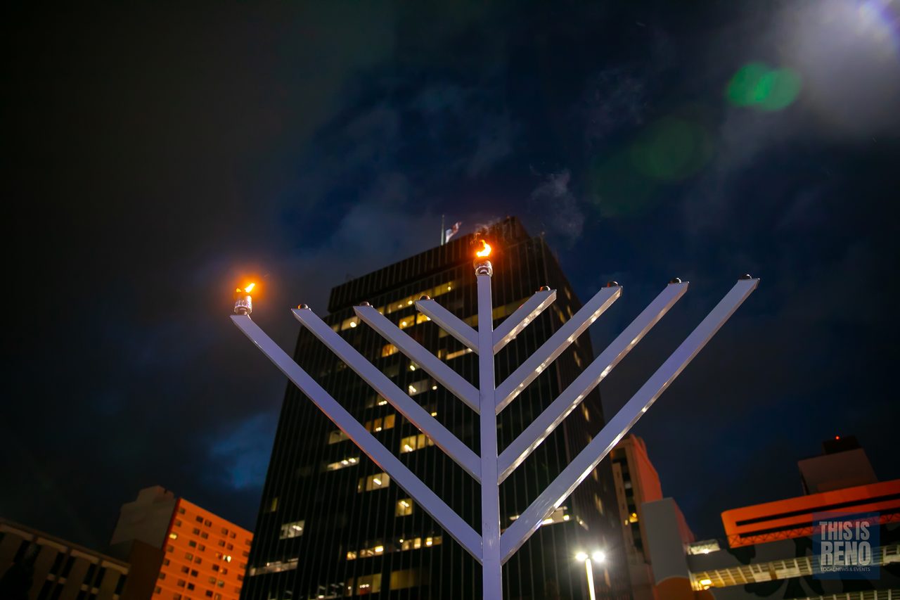 The lit menorah against the night sky over City Plaza