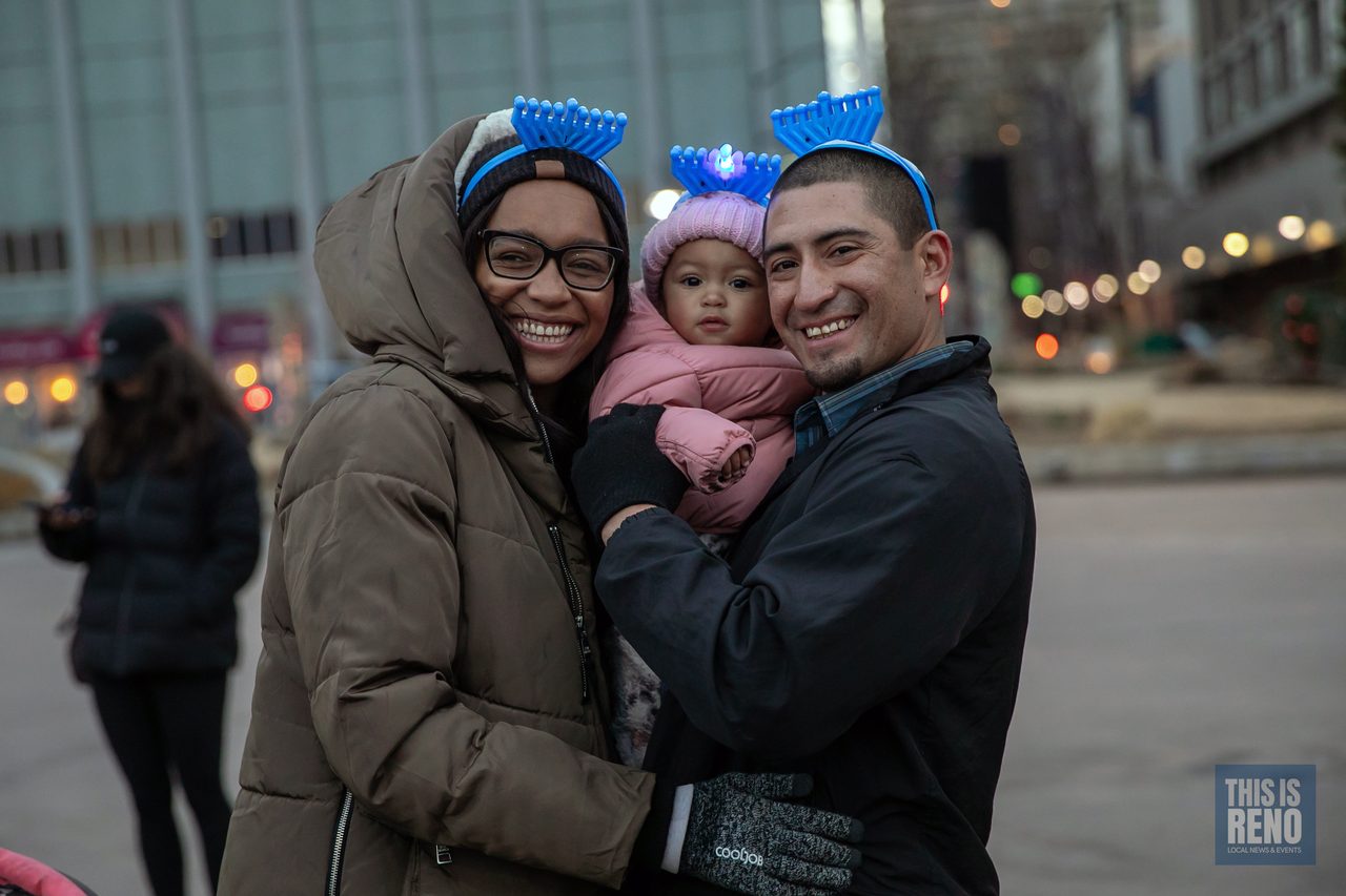 Parents and their baby wearing glowing menorah headbands
