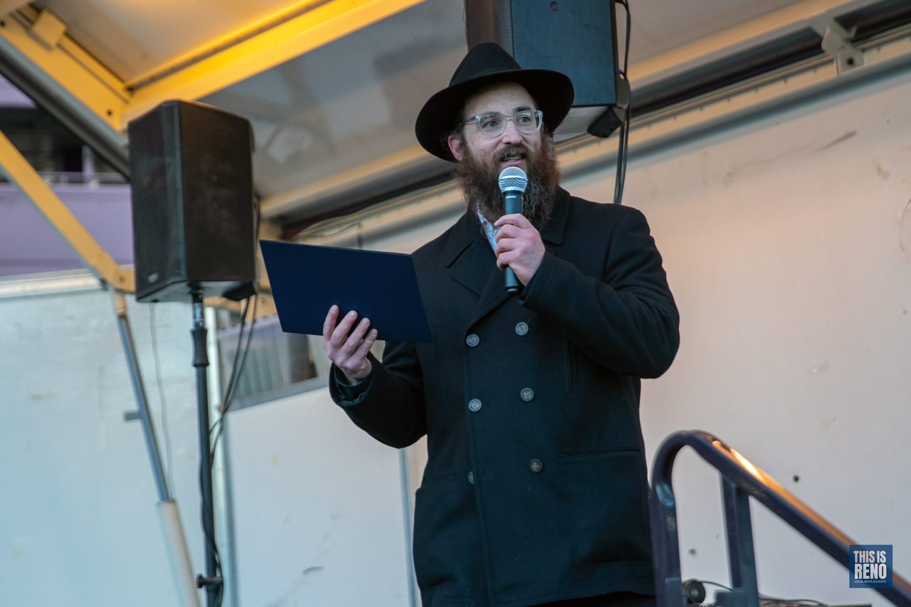 A rabbi speaking on stage with a microphone