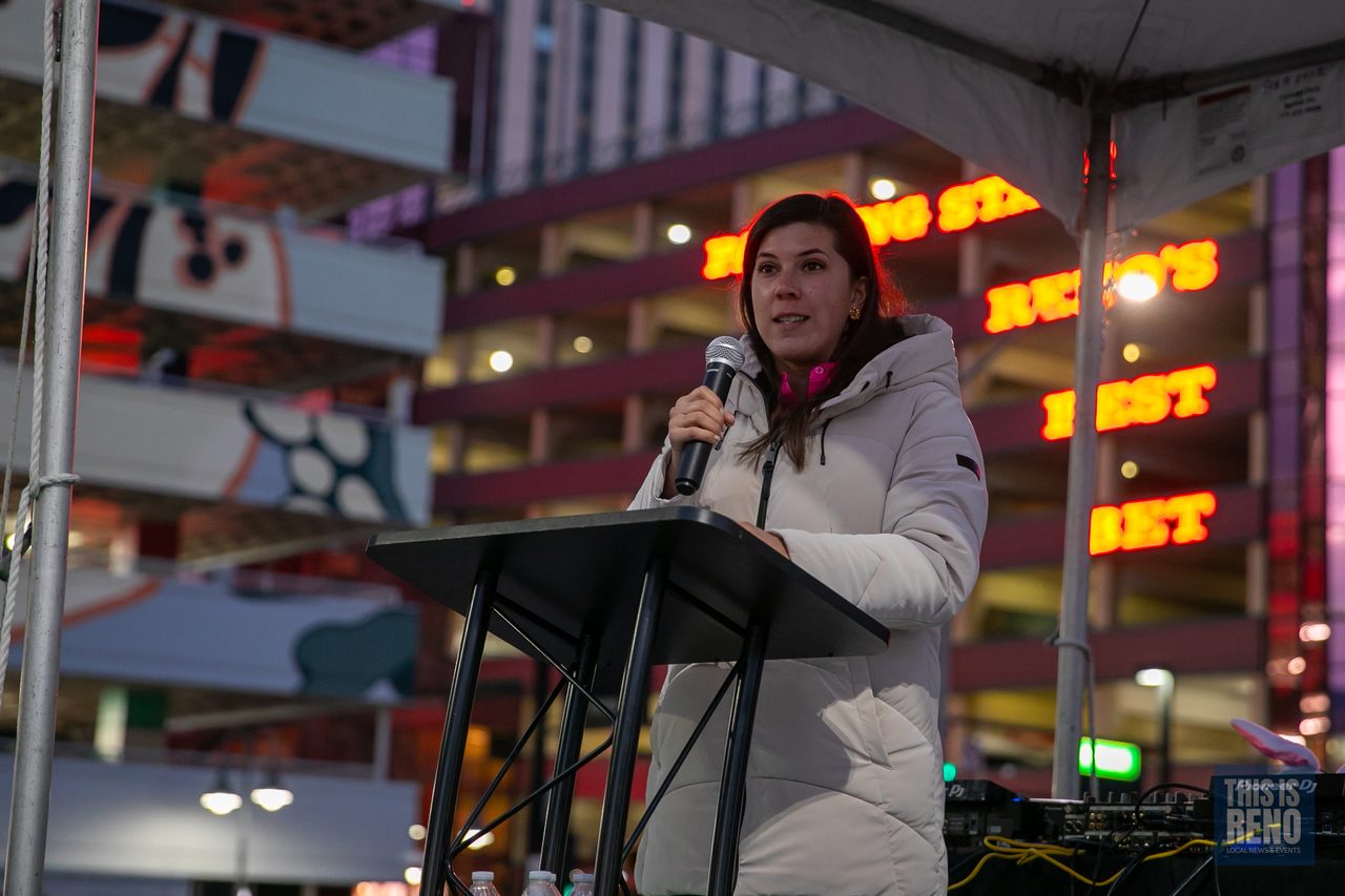 A speaker at the podium in front of the DJ tent