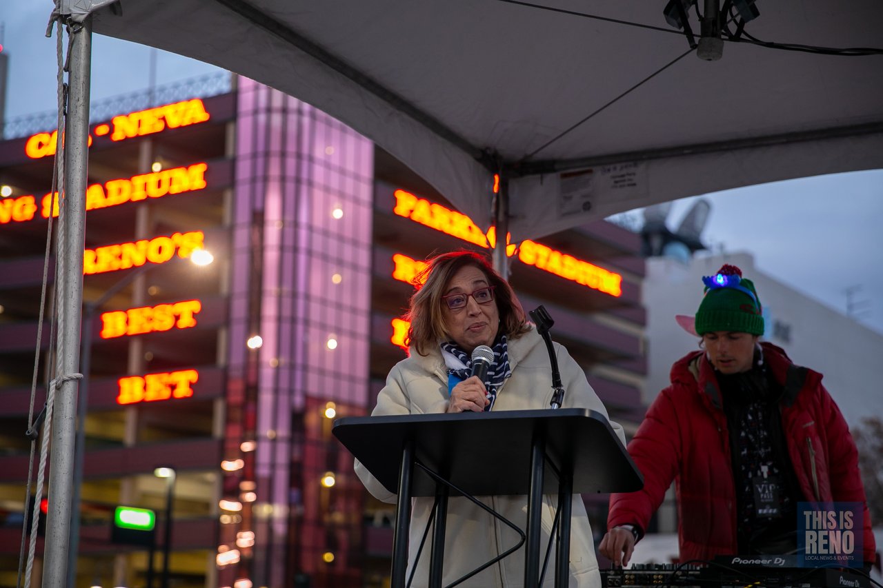 A speaker addresses the crowd from the podium under the tent