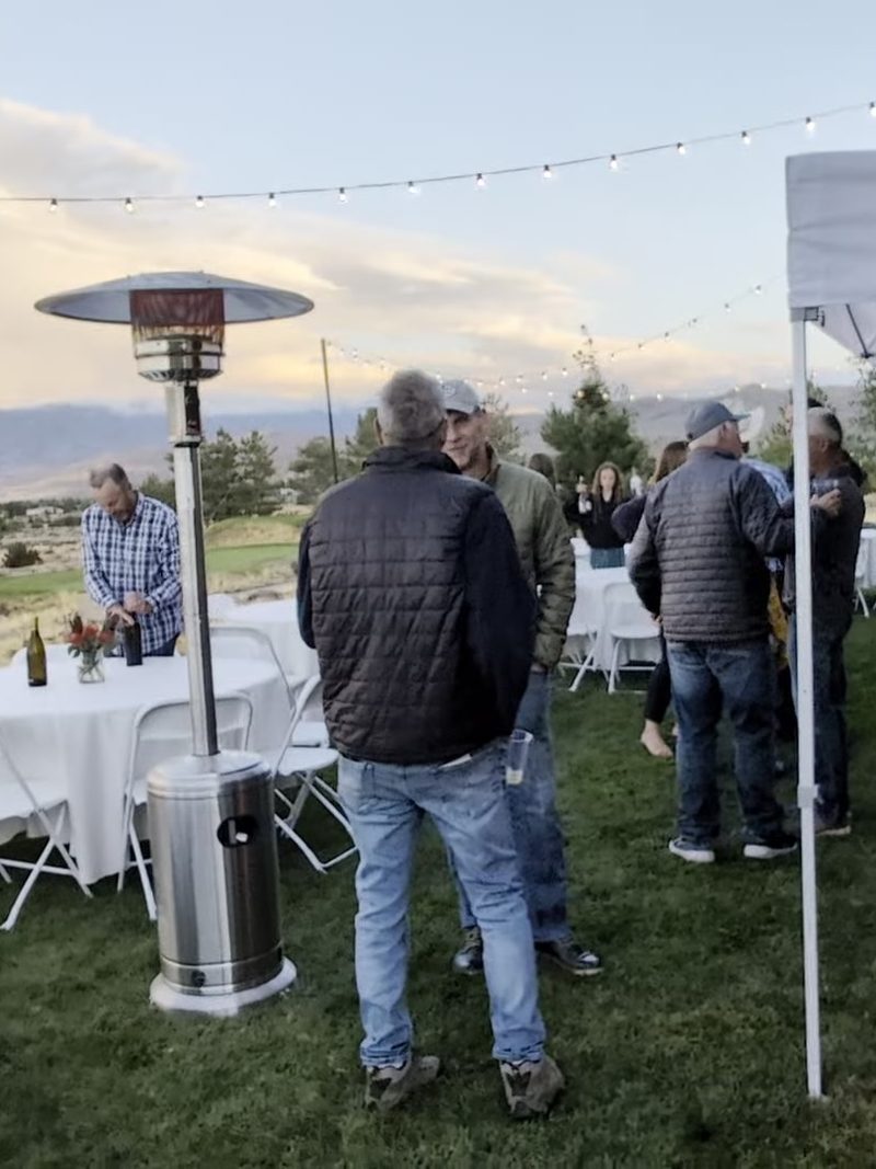 Guests on the lawn under the string lights and the paella tent