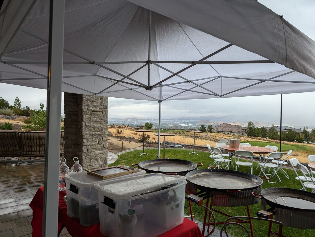 Paella pans set up under the white tent on the lawn